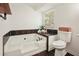 Bright bathroom featuring a soaking tub with stylish black tile accents and modern fixtures at 320 Creek Side Ct, Mcdonough, GA 30252