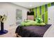 Bright bedroom featuring green wall design, window, and neutral carpet at 320 Creek Side Ct, Mcdonough, GA 30252