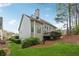 Rear exterior view showcases a multi-story home with a deck and manicured landscaping at 4847 Sara Creek Way, Sugar Hill, GA 30518