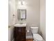 Small powder room features a wooden vanity with a sink and mirror at 4847 Sara Creek Way, Sugar Hill, GA 30518