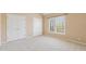 Bedroom with neutral walls and plush carpet, featuring a window and closet at 4847 Sara Creek Way, Sugar Hill, GA 30518