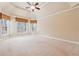 Spacious bedroom with a tray ceiling, carpet, and large windows at 4847 Sara Creek Way, Sugar Hill, GA 30518