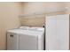 Bright laundry room with white washer, dryer, storage cabinets and wire rack shelving at 4847 Sara Creek Way, Sugar Hill, GA 30518