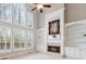 Bright living room with a fireplace, built-in shelves, and large windows offering scenic views at 4847 Sara Creek Way, Sugar Hill, GA 30518