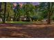 The home's front lawn is shaded by mature trees and includes a trimmed evergreen landscape and a side-entry garage at 2701 East Mill Sw Way, Conyers, GA 30094