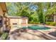 Backyard featuring a refreshing pool, stone patio, and lush landscaping creating a private oasis at 2701 East Mill Sw Way, Conyers, GA 30094