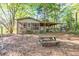Exterior shot of house with screened-in porch surrounded by lush greenery and a picnic table at 2701 East Mill Sw Way, Conyers, GA 30094