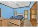 Blue bedroom with wooden trim and furniture including bed, dresser and two windows at 2701 East Mill Sw Way, Conyers, GA 30094
