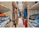 Walk-in closet featuring wooden shelves and built-in lighting and packed full of clothing at 2701 East Mill Sw Way, Conyers, GA 30094
