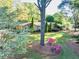 Charming home with a well-maintained front yard featuring colorful flowers and mature trees at 2701 East Mill Sw Way, Conyers, GA 30094