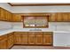 Traditional kitchen featuring wood cabinets, white countertops, and a window with blinds at 2701 East Mill Sw Way, Conyers, GA 30094