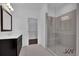 Modern bathroom with a glass shower, vanity, and walk-in closet access at 3764 Sage Park Way, Suwanee, GA 30024