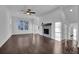 Open living room with hardwood floors, stone fireplace, recessed lighting, and large windows at 3764 Sage Park Way, Suwanee, GA 30024