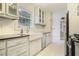 Bright kitchen featuring white cabinets, farmhouse sink, subway tile backsplash, and modern appliances at 1794 Charline Ne Ave, Atlanta, GA 30306