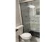 Bathroom shower has marble walls, glass doors, and dark pebble floor at 2250 Camp Town Way, Lawrenceville, GA 30044