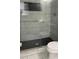 Modern bathroom featuring elegant marble-look tiles and a glass-enclosed shower with dark hexagon-shaped tiles at 2250 Camp Town Way, Lawrenceville, GA 30044