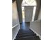 Dark wood staircase leading to a bright entryway featuring a door with transom window at 2250 Camp Town Way, Lawrenceville, GA 30044