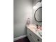 A well-lit bathroom with a round mirror and white vanity, plus bronze fixtures at 3225 Warren Creek Sw Dr, Hiram, GA 30141