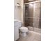 Bathroom featuring tiled shower with glass doors, quartz countertop, and tiled floor at 4125 Hidden River Dr, Cumming, GA 30028
