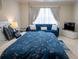 Inviting bedroom with a blue sofa, plush bedding, and elegant curtains at 4125 Hidden River Dr, Cumming, GA 30028