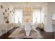 Bright dining room with modern chandelier and white furniture at 4125 Hidden River Dr, Cumming, GA 30028