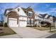 Charming two-story home boasts a stone and white painted brick facade, and a spacious two-car garage at 4125 Hidden River Dr, Cumming, GA 30028