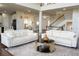 Open-concept living room with stylish sofas, a round coffee table, hardwood floors, and a staircase at 4125 Hidden River Dr, Cumming, GA 30028
