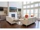 Spacious living room with a stone fireplace, large windows, comfortable sofas, and chic decor at 4125 Hidden River Dr, Cumming, GA 30028