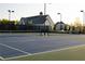 The community tennis court is surrounded by a neighborhood and lush, mature trees at 4125 Hidden River Dr, Cumming, GA 30028