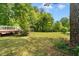 Large grassy backyard is surrounded by mature trees, offering plenty of privacy and space to play at 112 Bernice Dr, Lawrenceville, GA 30045