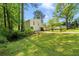Spacious yard surrounding this lovely home with an attached garage, beautiful shade trees and lush greenery at 112 Bernice Dr, Lawrenceville, GA 30045