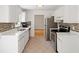 Galley kitchen featuring white cabinets, stainless steel appliances, and tiled backsplash at 112 Bernice Dr, Lawrenceville, GA 30045