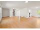Open-concept living area with hardwood floors, stairs to 2nd floor and views of the kitchen and backyard at 112 Bernice Dr, Lawrenceville, GA 30045