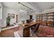 Basement office featuring concrete floors, white walls, staircase, wooden desk, and bookshelves at 172 Haynes Sw St # 108, Atlanta, GA 30313