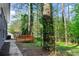 A Backyard view with a wooden deck, mature trees, and a walkway leading to the house at 2318 Plantation Dr, Atlanta, GA 30344