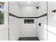 Beautifully tiled walk-in shower with niche, and sleek fixtures in this modern updated bathroom at 2318 Plantation Dr, Atlanta, GA 30344