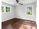 Sun-drenched bedroom featuring hardwood floors and two windows showcasing the verdant neighborhood at 2318 Plantation Dr, Atlanta, GA 30344