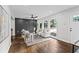Open-concept living room with an accent wall, hardwood floors, a ceiling fan, and access to the front entrance at 2318 Plantation Dr, Atlanta, GA 30344