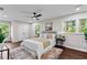 Calming main bedroom with a ceiling fan, natural light, hardwood floors, and views of the lush greenery at 2318 Plantation Dr, Atlanta, GA 30344