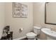Half bathroom features a modern pedestal sink and decorative wall art at 6160 Shiloh Woods Dr, Cumming, GA 30040
