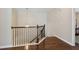 Hallway with stained wood banister and wrought iron spindles overlooks hardwood floors at 6160 Shiloh Woods Dr, Cumming, GA 30040