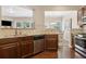 Open kitchen showcasing stainless steel appliances, granite counters, and view to adjacent dining and living areas at 6160 Shiloh Woods Dr, Cumming, GA 30040
