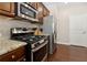 Kitchen featuring stainless steel appliances, granite countertops and rich wood cabinetry at 6160 Shiloh Woods Dr, Cumming, GA 30040