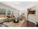 Cozy living room featuring hardwood floors, neutral walls, and views into the breakfast area at 6160 Shiloh Woods Dr, Cumming, GA 30040