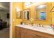 Bathroom featuring dual sinks, wood cabinets, white countertop, and two decorative mirrors at 990 Fox Valley Trl, Stone Mountain, GA 30088