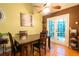 Dining room with wood floors and a ceiling fan with access to a back patio through double doors at 990 Fox Valley Trl, Stone Mountain, GA 30088