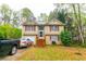 Charming two-story home featuring a well-maintained lawn and a welcoming front porch with garage and two parked cars at 990 Fox Valley Trl, Stone Mountain, GA 30088