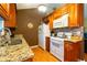 Close up view of kitchen with wood cabinets, granite countertops and gas range at 990 Fox Valley Trl, Stone Mountain, GA 30088