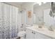 This bathroom features a shower with a leaf-patterned shower curtain, a toilet and a white sink at 1110 Croftmoore Lndg, Suwanee, GA 30024