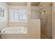 Bathroom featuring a soaking tub, walk-in shower, and tiled surround at 1110 Croftmoore Lndg, Suwanee, GA 30024